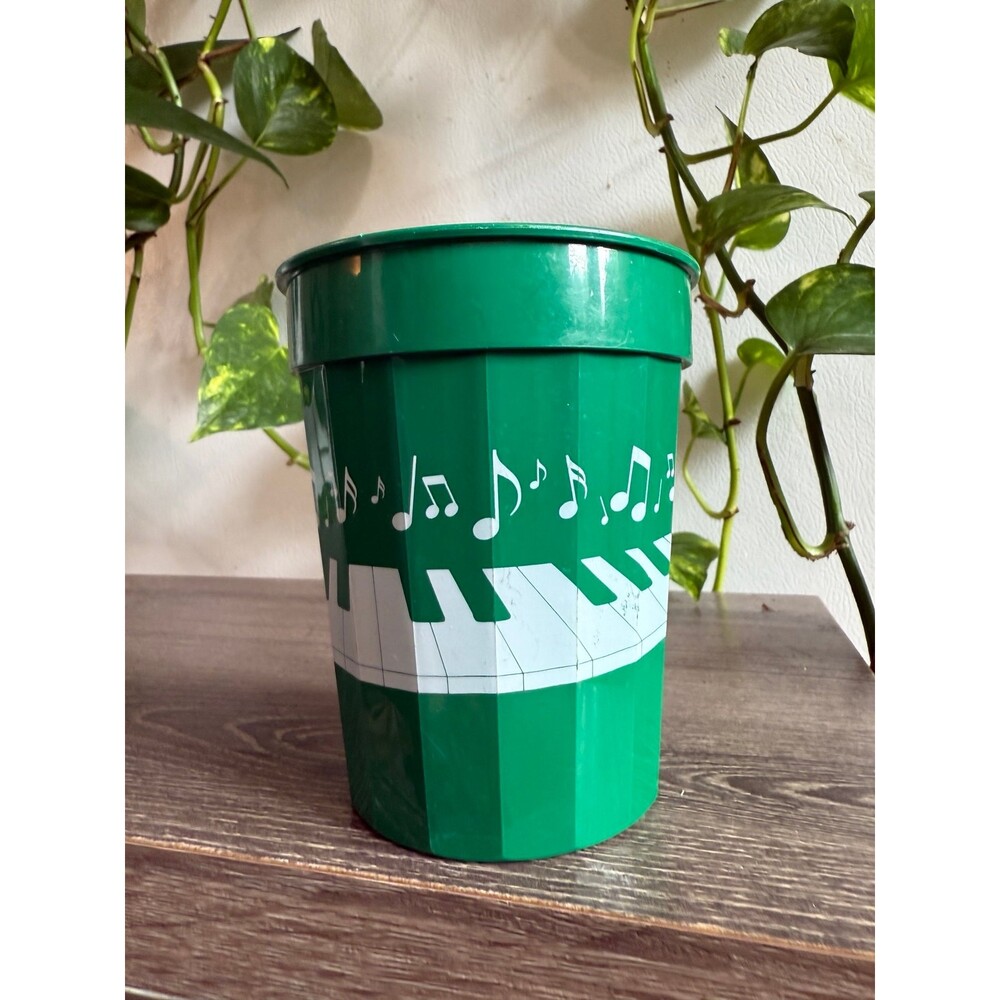 Green plastic cup with music notes and piano